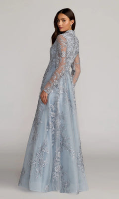 Wearing the Mac Duggal 21307, a long formal dress in light blue with sheer long sleeves and intricate floral-beaded embroidery, a woman stands looking over her shoulder.