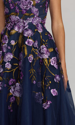 A person wearing the Mac Duggal 21358 ankle-length party dress in navy blue with purple and gold floral embroidery, shown from shoulder to mid-thigh against a neutral background.