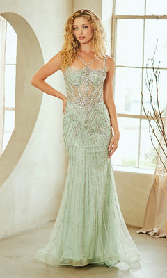 Woman wearing a light green evening gown with intricate detailing in a softly lit room.