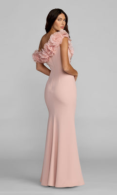 Woman in a light pink, floor-length Mac Duggal 21383 formal dress with striking 3D floral appliques on the shoulder, standing and facing backward with her head turned toward the camera.