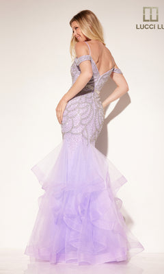 A woman stands facing away against a plain background, wearing the Open-Back Beaded Mermaid Prom Dress: Lucci Lu 2147—an elegant, fitted gown with sparkling beadwork and a dramatic mermaid silhouette.