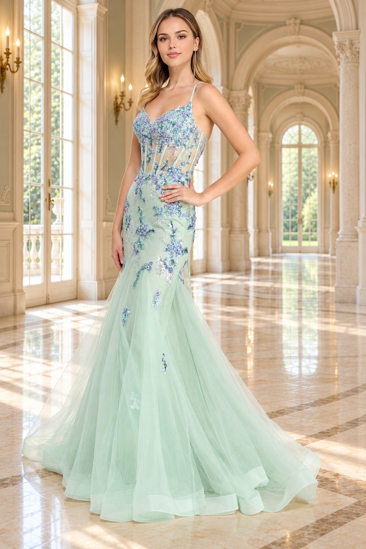 Amelia Couture 2164 is a floor-length, mint green mermaid prom dress featuring a sheer bodice, spaghetti straps, and sequin flower appliques.