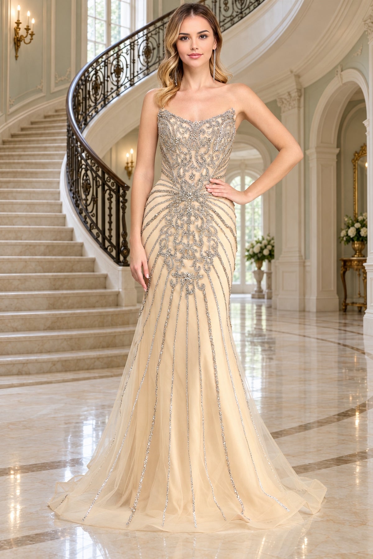 Amelia Couture 2165 champagne-colored floor-length mermaid prom dress with a strapless sweetheart neckline and intricate silver beadwork extending down the bodice and skirt.