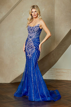Amelia Couture 2165 is a royal blue, floor-length strapless mermaid prom dress with silver sequin stripes and intricate silver embellishments on the bodice.