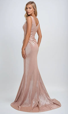 A woman poses against a plain light background in the Juliet 218 long prom dress—a fitted, sleeveless, rose gold metallic gown with a faux-wrap bodice and slight train.