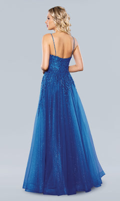 Woman wearing the Stella Couture 22027, a floor-length blue A-line prom dress with thin straps and floral detailing, shown from the back against a plain light background.