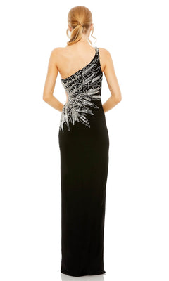 A woman in the Long Formal Dress 2207 by Mac Duggal—black, one-shoulder, with silver sequin back detailing and a sleek side slit—stands with her back to the camera.