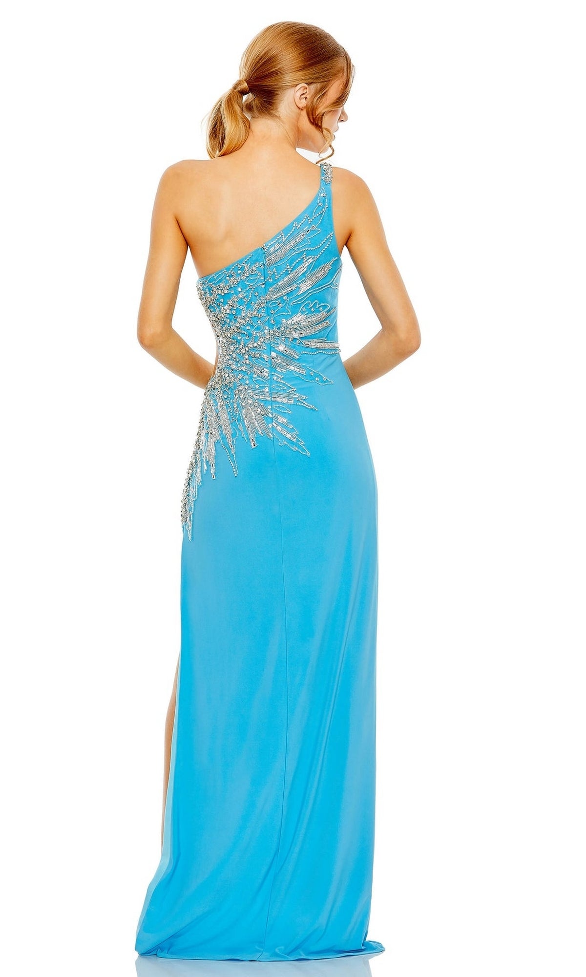 A woman showcases the Long Formal Dress 2207 by Mac Duggal, a fitted, bright blue one-shoulder gown with silver sequin back detailing and an elegant side slit, standing with her back to the viewer.