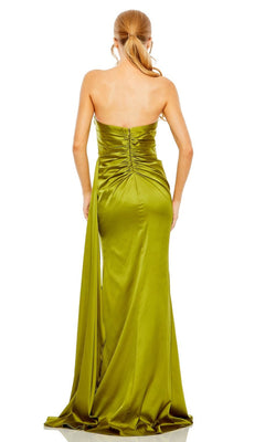 A woman models the Mac Duggal 2211 Side-Drape Strapless Prom Gown—an olive green satin dress with a pleated bodice and draped train—shown from the back against a white background.