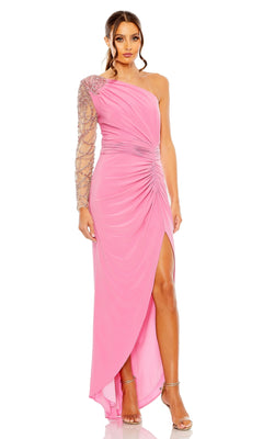 A woman wears the Long Formal Dress 2215 by Mac Duggal, featuring a pink, one-shoulder design with a jeweled long sleeve and thigh-high slit, paired with silver high-heeled sandals.
