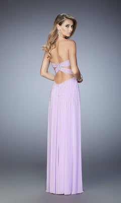 A woman stands against a plain gray background wearing the La Femme Strapless A-Line Designer Prom Dress 22230—lavender, floor-length, featuring a back cutout and sparkling rhinestone embellishments.