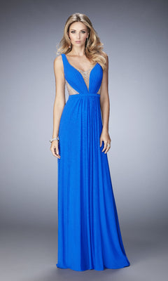A woman wearing the La Femme 22238 long prom dress, a sleeveless royal blue A-line gown with mesh cutouts, stands against a plain gray background.