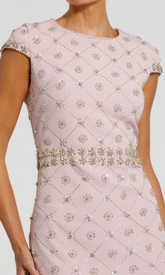 A woman wears the Mac Duggal 2234, a mauve pink wedding guest dress with short sleeves, diamond pattern, and embellished floral beading—an elegant midi dress for any stylish event.