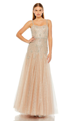 A woman poses with one hand on her hip, wearing the Long Formal Dress 2236 by Mac Duggal—an elegant, sleeveless champagne A-line gown adorned with sparkling beads and sequins.