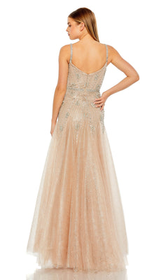 A woman stands with her back to the camera, wearing the Long Formal Dress 2236 by Mac Duggal—a floor-length light beige tulle ball gown with thin straps and silver embellishments.