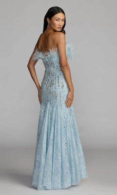A woman models the Mac Duggal 2238 long formal dress—a light blue, off-the-shoulder gown with a feather-embellished, sequin neckline—standing partially turned toward the camera against a plain background.