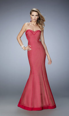 A woman poses in the La Femme Dress 22425, a strapless sweetheart, form-fitting red gown with horizontal black stripes, floor-length, against a plain gray background.