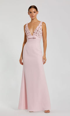 A woman models the Mac Duggal 2278, a floor-length, sleeveless pale pink prom dress featuring a deep V-neck and floral-embellished beaded bodice, standing against a plain background.
