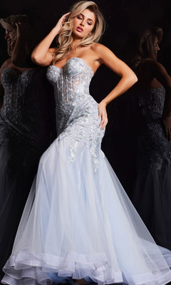 A woman poses against a dark reflective background wearing the Jovani Strapless Long Light Blue Prom Dress 22924—a modern, fitted mermaid gown featuring a sheer corset bodice, floral embroidery, and a flowing tulle skirt.