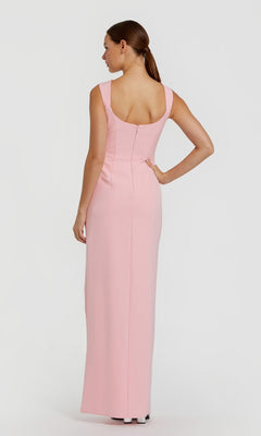 A woman faces away, wearing the Mac Duggal 2293—a long, sleeveless light pink formal dress with a fitted bodice and scoop back.