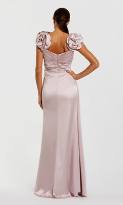 A woman is seen from behind wearing the Mac Duggal 2299 Rose Pink Long Satin Formal Dress with rosette shoulder details, perfect for an elegant evening look.