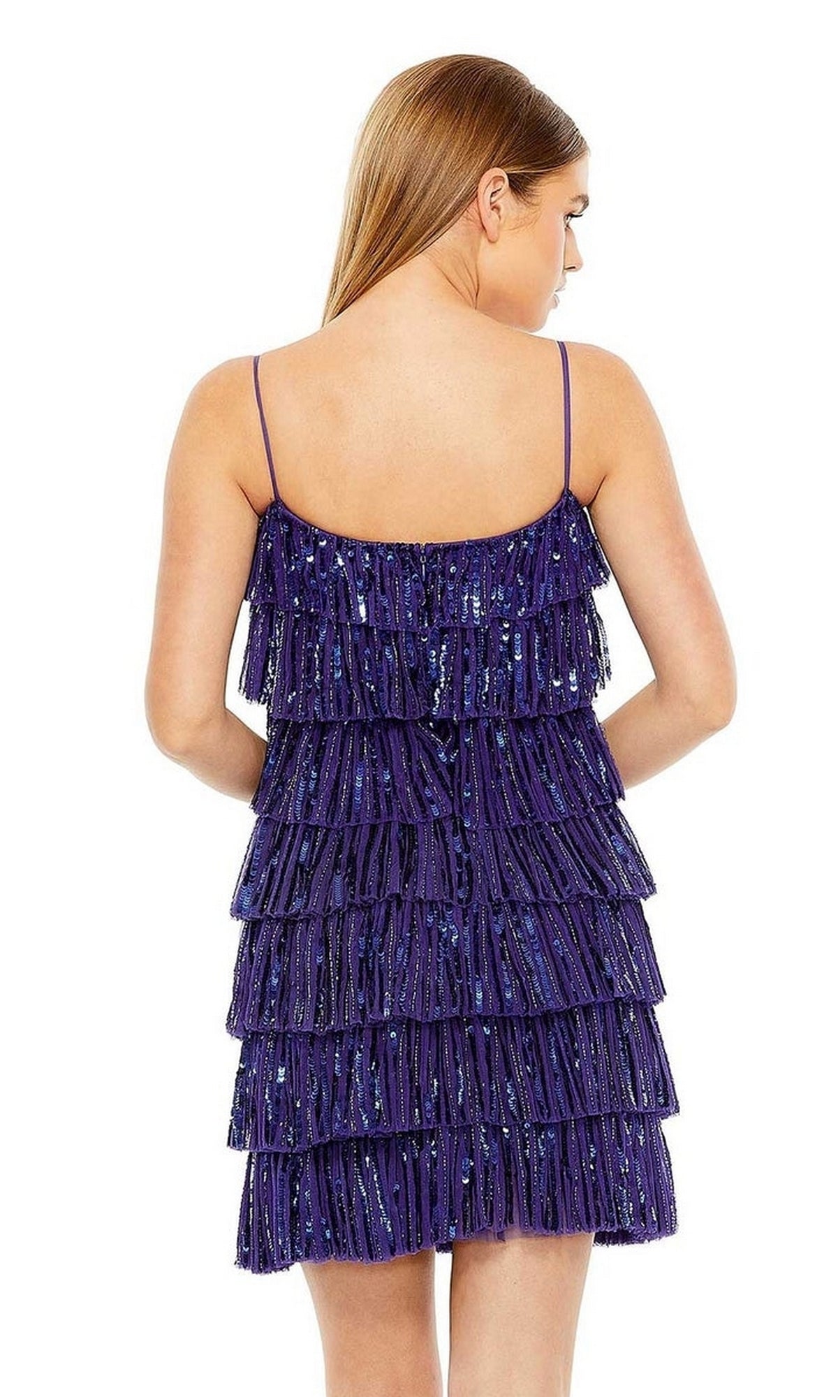 A woman with straight brown hair is shown from the back wearing a Mac Duggal 23001 Short Ruffled Semi-Formal Dress, a sleeveless purple party dress with sequin accents and tiered fringe.
