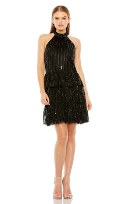 Model in Mac Duggal Short Black Homecoming Dress 23012, a sleeveless halter design with layered fringe, stands with arms at her sides and feet together in strappy high-heeled sandals.