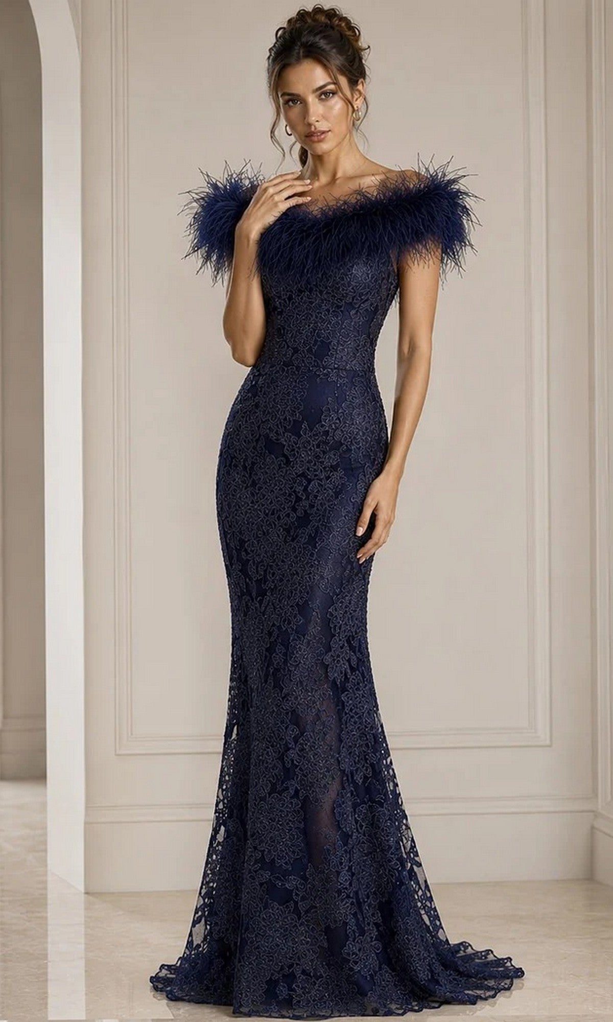 A woman stands in an elegant, neutral-toned room wearing the Jovani 23030 long formal dress in navy—a floor-length beaded floral lace gown featuring a feathered off-the-shoulder neckline.