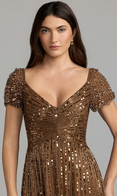 A woman stands facing forward against a neutral background, modeling the Short Sleeve Sequin Formal Dress: Mac Duggal 23042 in brown, which features sparkling sequins and short beaded sleeves—an elegant choice for a mother of the bride.
