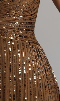 Close-up of the Mac Duggal 23042 Short Sleeve Sequin Formal Dress—a brown formal gown featuring horizontal and vertical rows of shiny sequins, with part of a person’s waist and arm visible against a neutral background, reminiscent of an elegant mother of the bride dress.