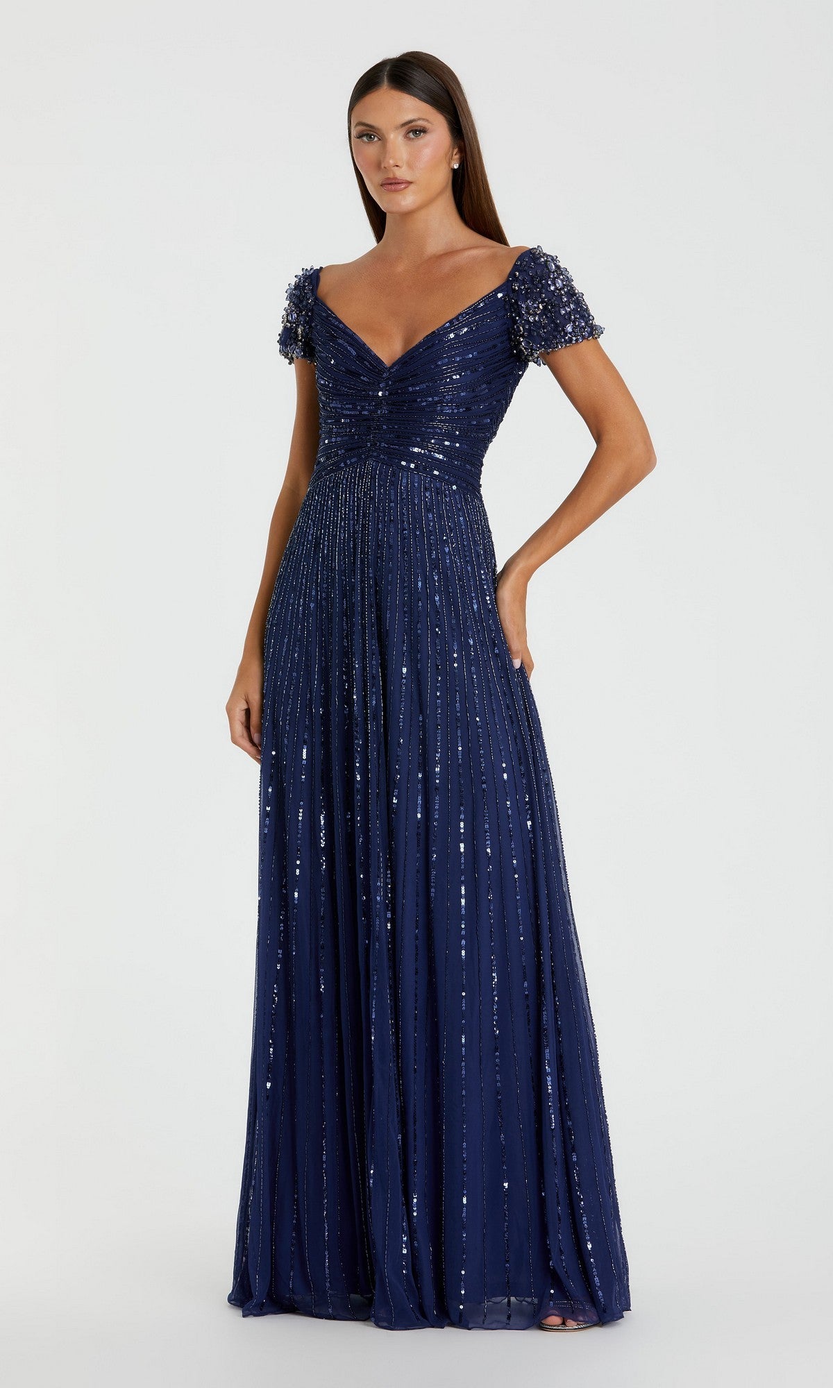 A woman wearing the Mac Duggal 23042 gold formal dress with short sleeves stands against a plain background.