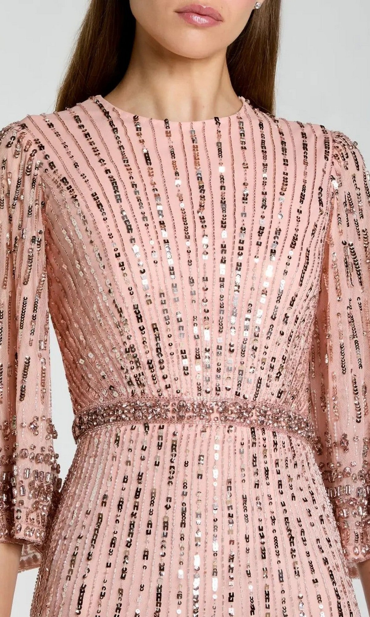 A woman wearing the Mac Duggal 23045 Long Formal Dress in pink, designed with vertical sequin stripes and beaded accents at the waist and sleeves.