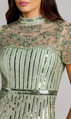 A close-up of a woman wearing the Mac Duggal 23075 long formal dress in sage green, adorned with bead and sequin embellishments and featuring sheer embroidered fabric on the upper chest and sleeves.