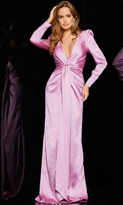 A woman wears the Jovani 23180, a floor-length pink satin formal dress with long sleeves, a deep V-neckline, and a knot detail at the waist, set against a black background.