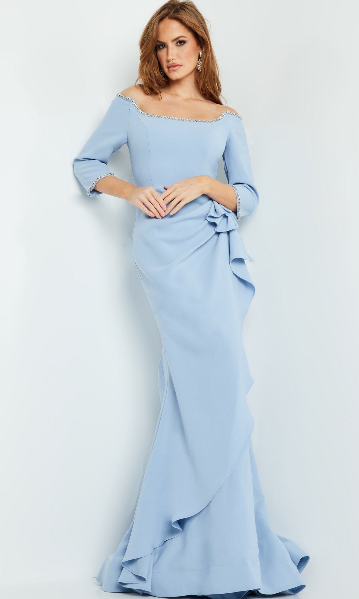 A woman stands against a plain background in the Jovani Long Formal Dress with Bead Trim 23190, featuring light blue fabric, three-quarter sleeves, pearl details, and ruffle accents.