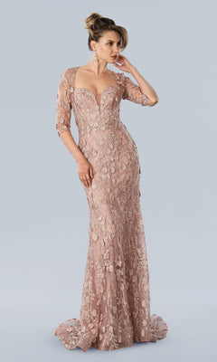 A woman wears the Long Formal Dress: Stella Couture 23311 in rose, featuring floral lace appliqué, three-quarter sleeves, and a sweetheart neckline, standing against a plain light gray background.