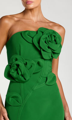 A woman wearing the Mac Duggal 2361 long formal dress, a strapless green crepe design featuring a fitted bodice and adorned with large fabric roses, leaves, and intricate 3D floral appliques across the chest and waist.