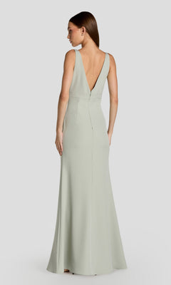 A woman models the Mac Duggal 2371 long formal dress, a sleeveless light green crepe gown with a deep V-back, standing against a plain light gray background.