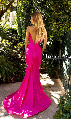 A woman with long blonde hair wears the Beaded-Neck Long Prom Dress: Jessica Angel 2375, a bright pink open-back gown with a flowing train, standing outdoors near green foliage and sunlight.