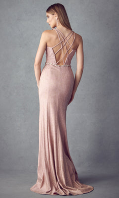 A woman models the Juliet 237 Long Prom Dress, a floor-length, shimmering light pink form-fitting gown with a strappy crisscross open back, standing against a plain gray background.