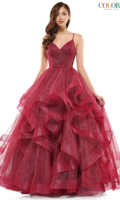 A woman stands against a plain background wearing the Layered Long Tulle Prom Ball Gown 2381, featuring spaghetti straps, a sleeveless design, deep red color, and a layered A-line tulle skirt.