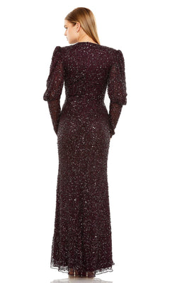 A woman faces away, wearing the Mac Duggal Long Formal Dress 24000—a floor-length, long-sleeved sequin gown with a fitted silhouette and subtly puffed shoulders.