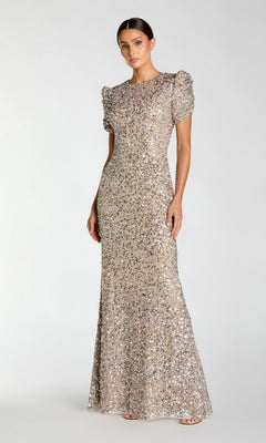 Woman modeling the Mac Duggal 24003 Short Sleeve Sequin Formal Dress, a fitted, floor-length gown with puff sleeves, against a plain light background.