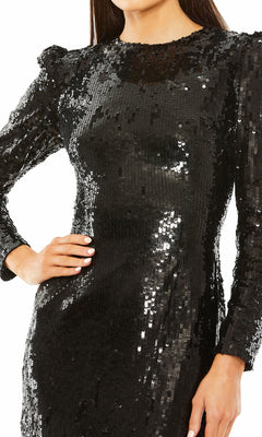 A woman models the Mac Duggal 24008 midi black sequin formal dress, standing facing forward with one hand on her hip.