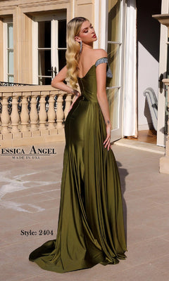Woman in an olive green, off-shoulder satin gown with silver strap detail stands on a terrace, facing away. Text: "Asymmetrical Long Prom Dress: Jessica Angel 2404. Made in USA.