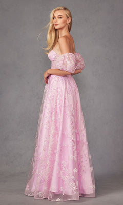 A woman stands in profile wearing the Puff-Sleeve Strapless Long Glitter Prom Dress 2404, a floor-length, off-the-shoulder gown with floral embroidery in light pink, set against a gray background.