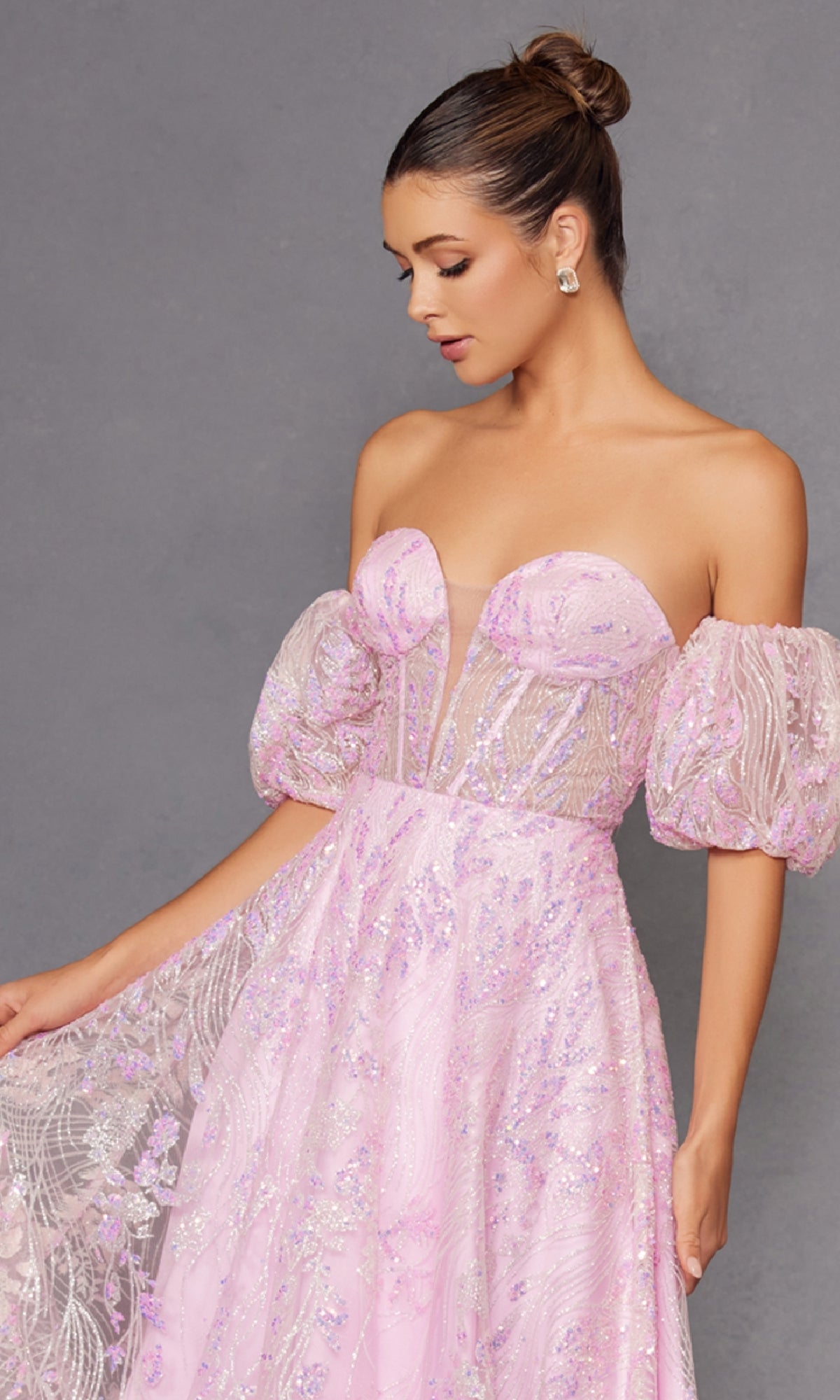 A woman models the Puff-Sleeve Strapless Long Glitter Prom Dress 2404 in light pink, with sheer puff sleeves and sparkling details, standing before a plain gray background.