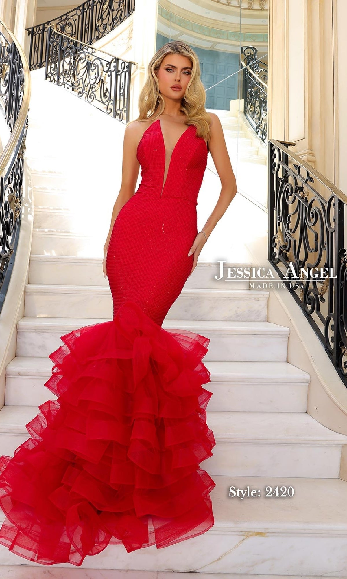Woman in a fitted Jessica Angel 2420 long ruffle mermaid prom dress with a deep V neckline stands on white marble stairs with black wrought iron railings. Text reads “Long Ruffle Mermaid Prom Dress: Jessica Angel 2420.”.