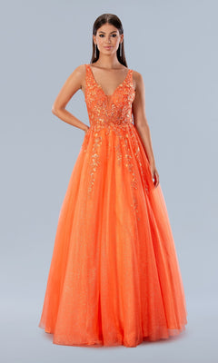 A woman poses in the Stella Couture 24203, a long glitter prom gown featuring a sleeveless, bright orange floral-embroidered bodice and a full sparkling tulle skirt, set against a plain background.