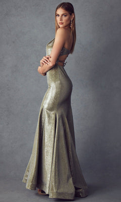 Woman in the Juliet 242 Long Prom Dress—shimmering, floor-length metallic gown with fitted bodice and open back—standing sideways against a plain gray background.
